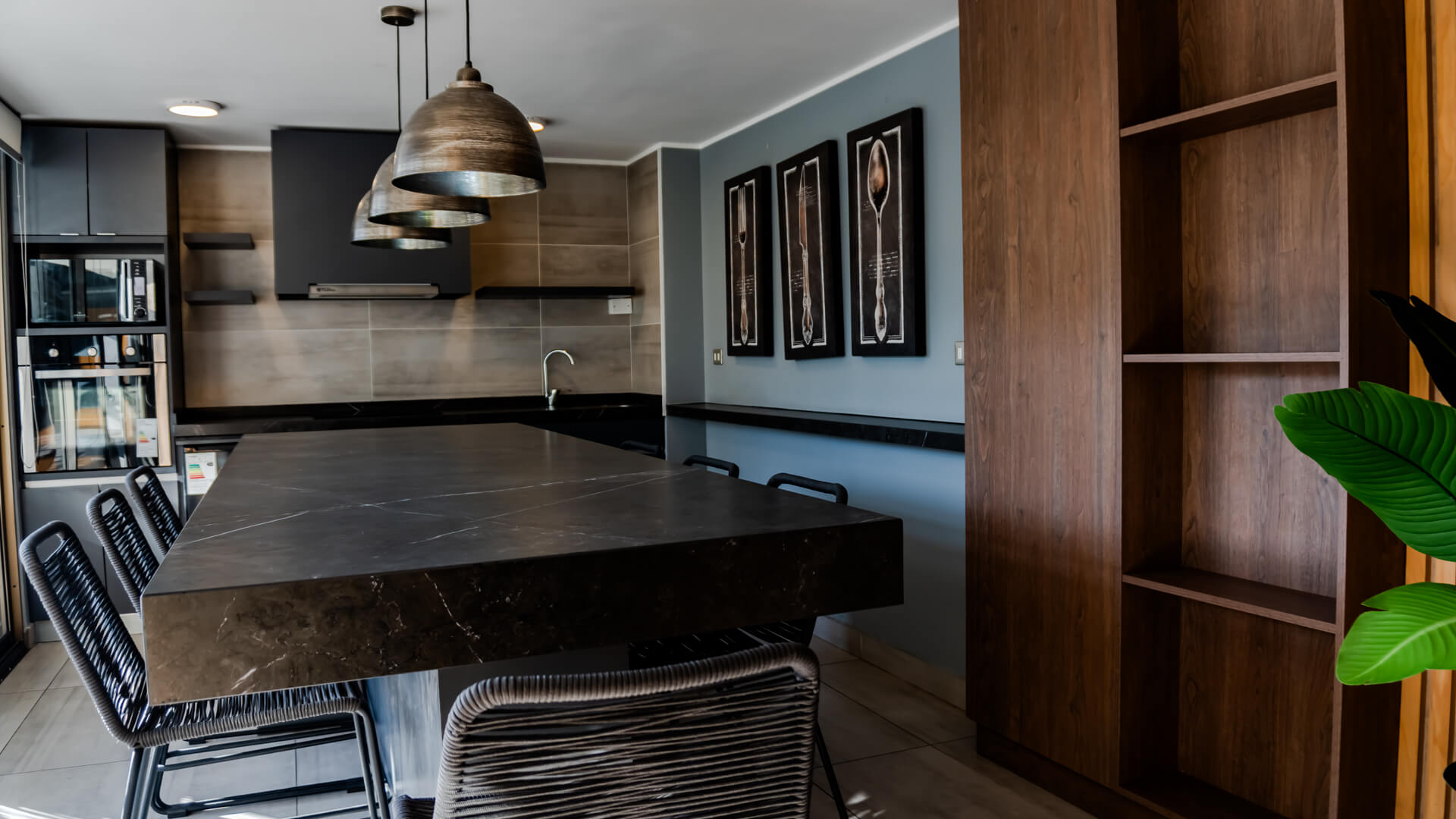 Salón gourmet con isla de mármol, cocina equipada y barra con piso altos